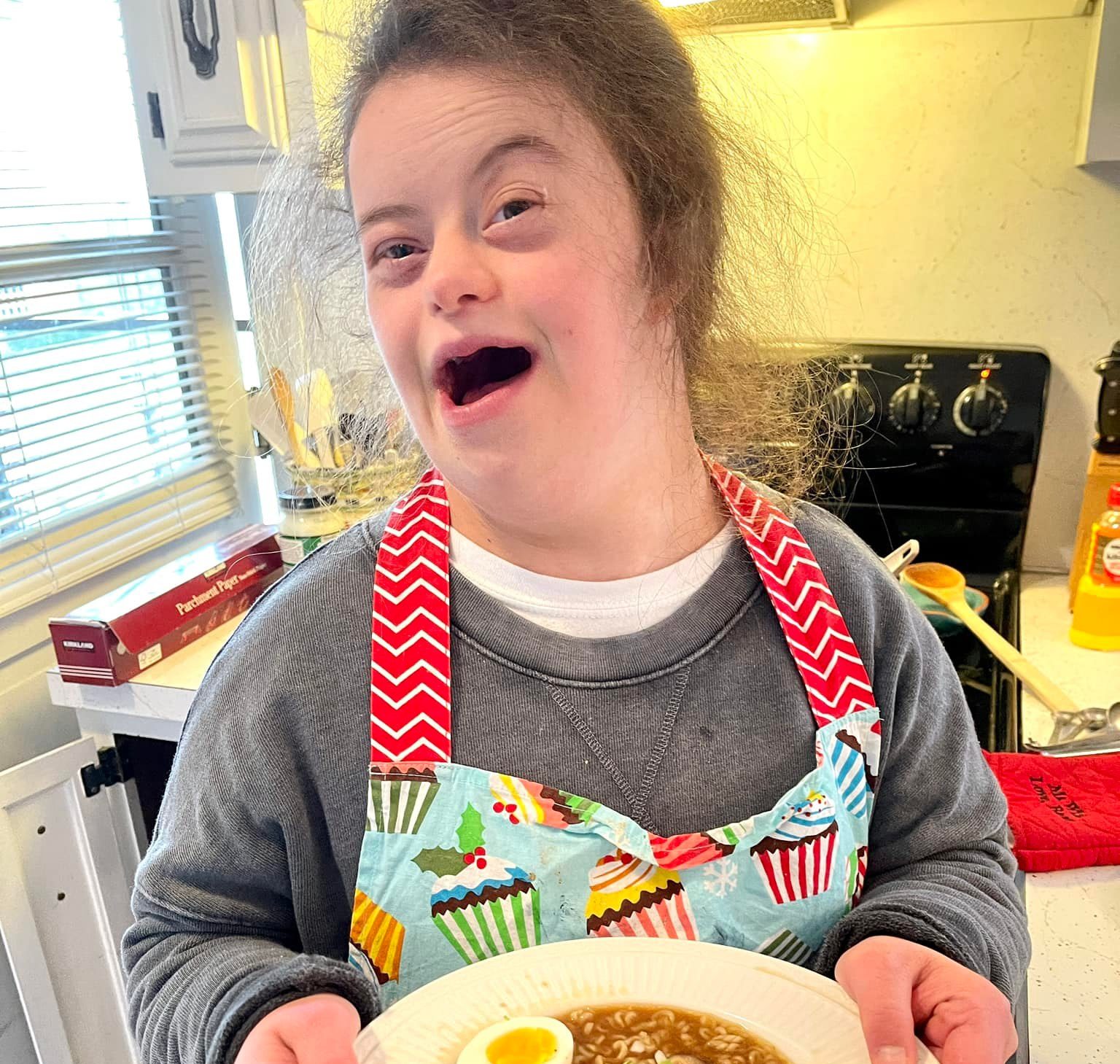 Maddie holding a bowl of ramen