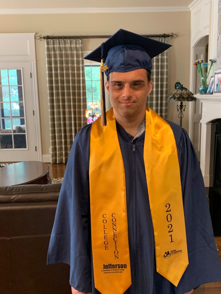 a smiling indian man with down syndrome on his college graduation day