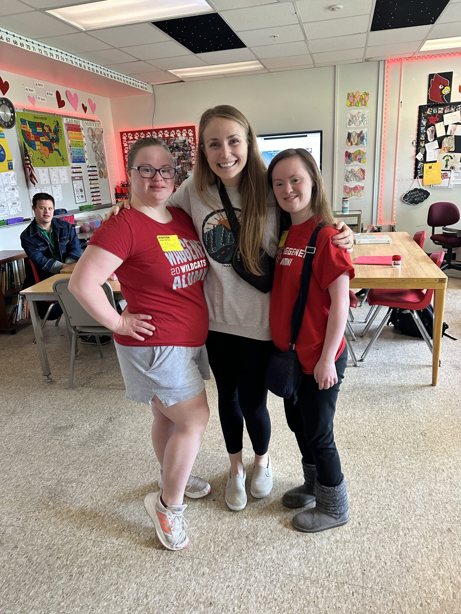 Megan and Madeline with their former teacher. All of the women smile