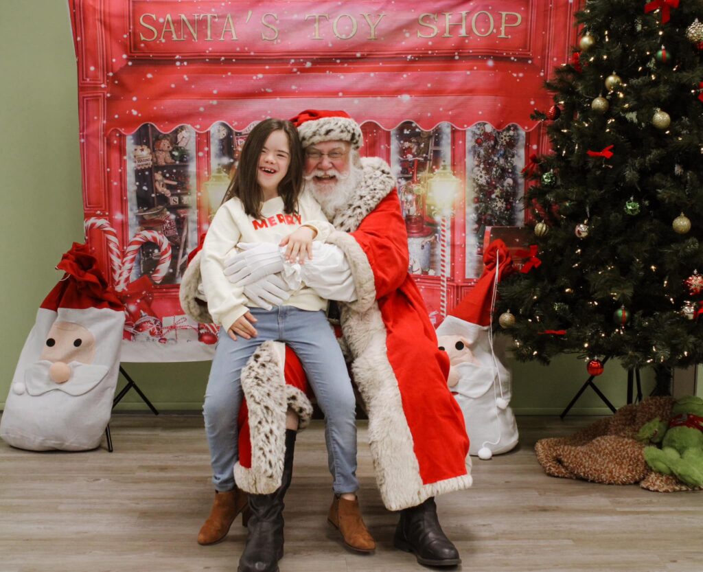 Santa in red with a little girl with Down syndrome